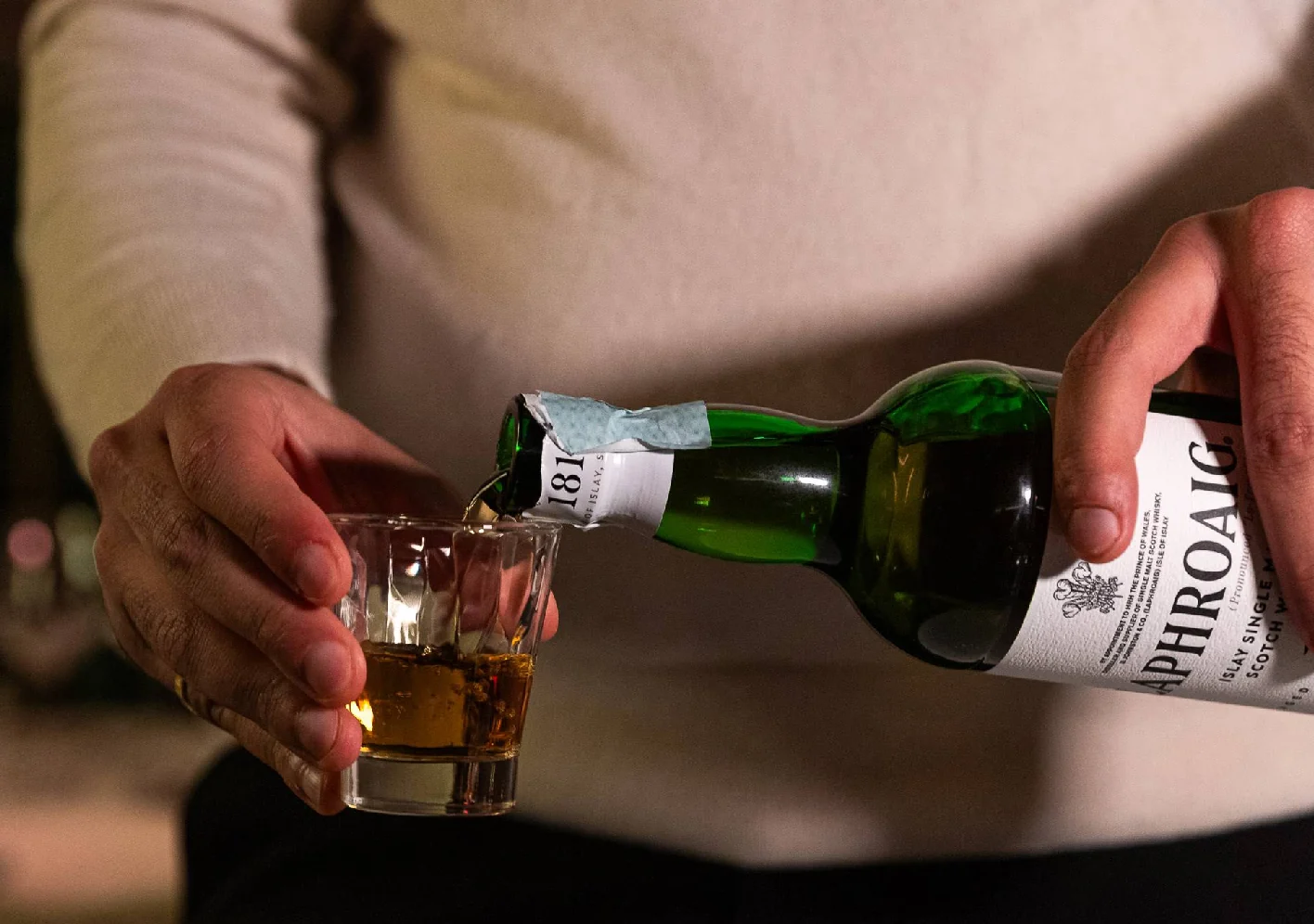 Uno shot di whisky versato da una bottiglia di scotch single malt