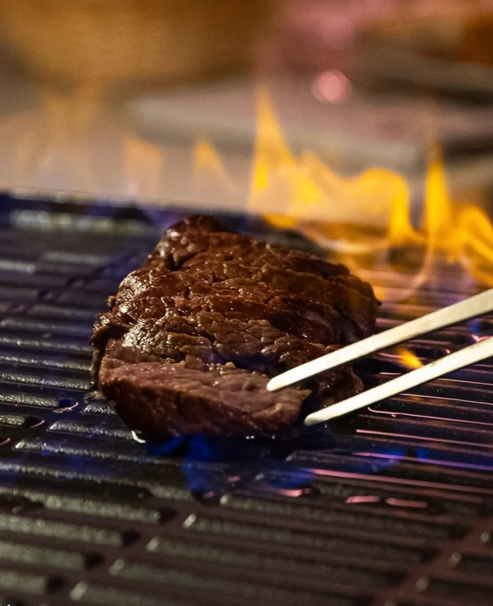 Una bistecca sulla griglia con la fiamma