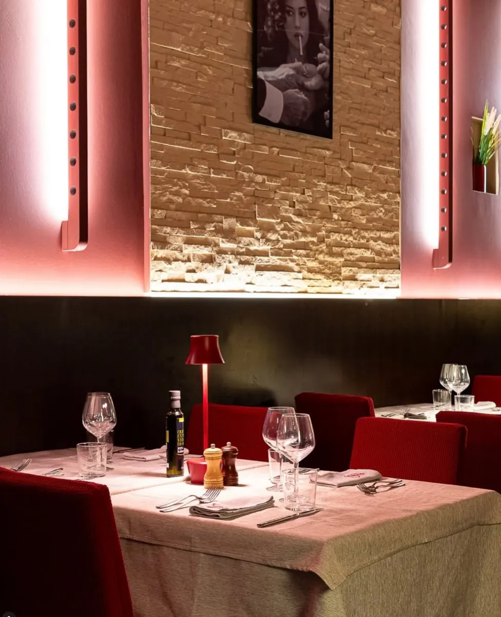 La sala illuminata di rosa con le sedie rosse